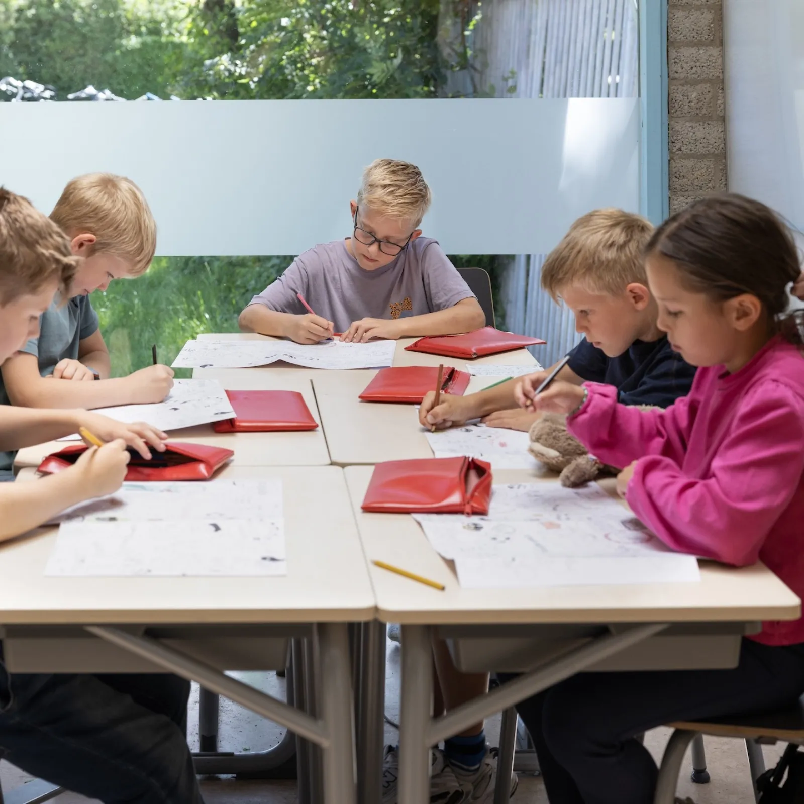 kinderen werkend aan tafel in de klas